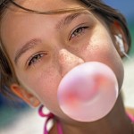 Teenager girl makes chewing gum's bubble